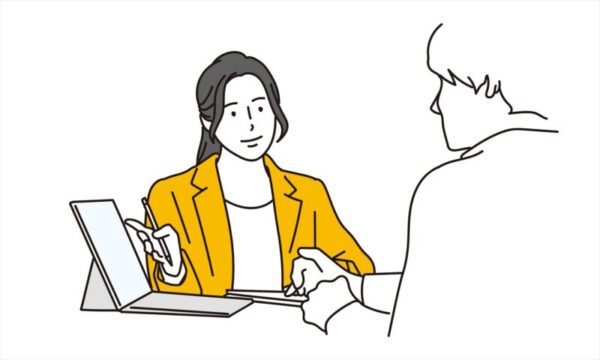 PCを見せて説明する女性
