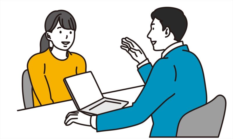 女性来訪者に説明する男性ビジネスパースン