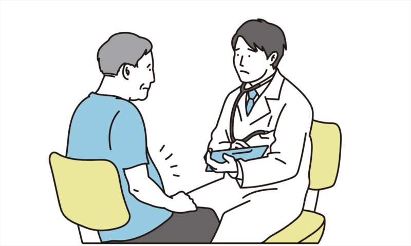 医師の診察を受けるメタボ風の男性