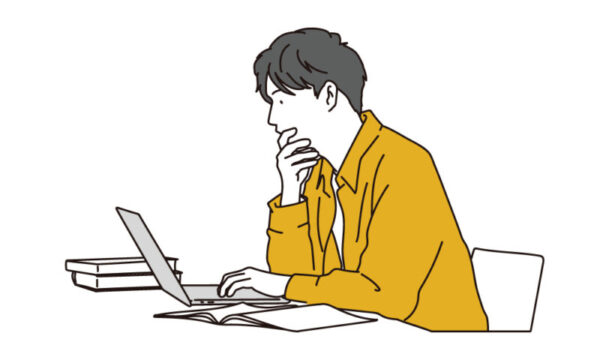 パソコンを見ながら考える男性